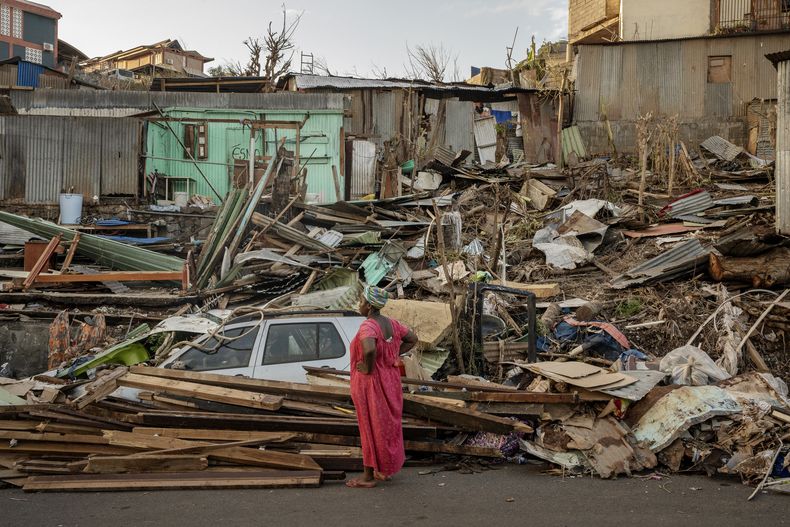 Una mujer observa una casa destruida en Mamoudzou, Mayotte, el jueves 19 de diciembre de 2024. (AP foto/Adrienne Surprenant)