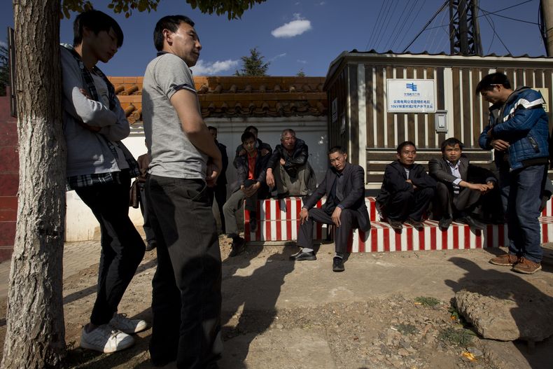 Familiares y amigos de una v&iacute;ctima muerta en el ataque del s&aacute;bado por la noche esperan a ver su cad&aacute;ver frente a una funeraria en Kunming, en la provincia meridional china de Yunnan, el lunes 3 de marzo del 2014. (Foto AP/Alexander F.