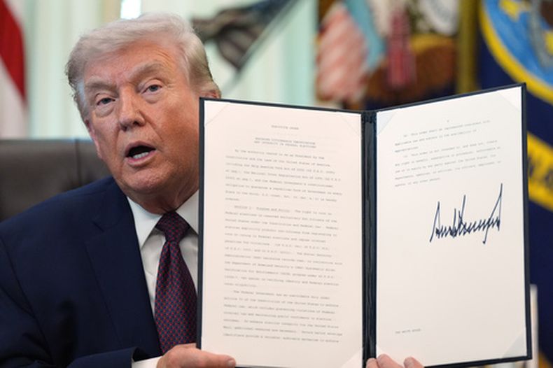 El presidente Donald Trump sostiene una orden ejecutiva recién firmada en el Despacho Oval de la Casa Blanca, el martes 31 de marzo de 2026, en Washington. (AP Foto/Alex Brandon)