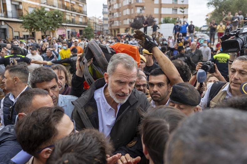 El rey Felipe VI de España habla con sobrevivientes de las inundaciones en España en un ambiente tenso, el domingo 3 de noviembre de 2024, en Paiporta, cerca de Valencia, España. (AP Foto/David Melero)