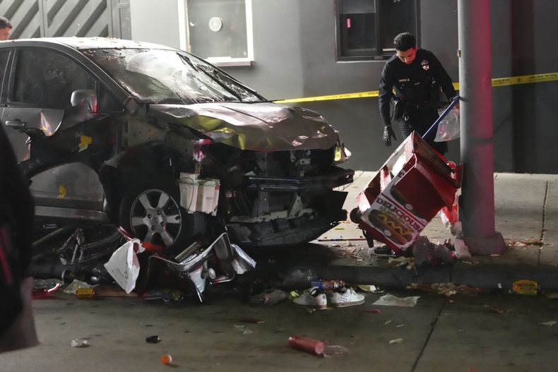Un vehículo en la acera tras embestir a una multitud de personas que esperaba para entrar a un club nocturno en un concurrido bulevar de Los Ángeles, el sábado 19 de julio de 2025, dejando varios heridos, algunos de gravedad. (AP Foto/Damian Dovarganes)