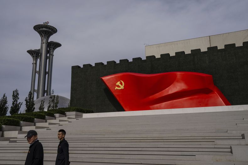 ARCHIVO - Visitantes pasan frente a una bandera del Partido Comunista Chino en el museo del partido en Beijing, el 19 de octubre de 2023. (AP Foto/Louise Delmotte, archivo)