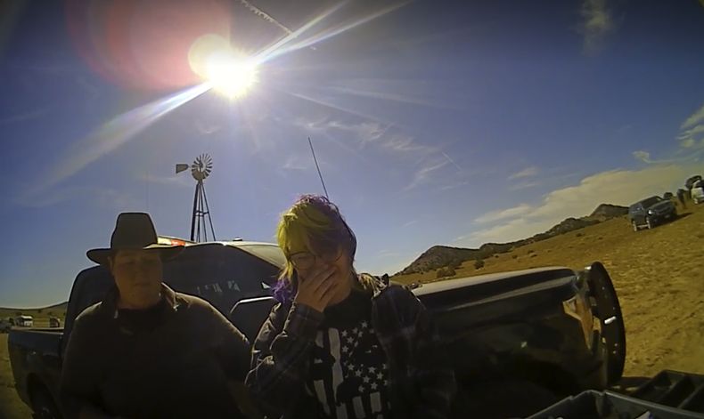 En esta captura de pantalla del video de una cámara de solapa proporcionada por la Oficina del Jefe de Policía del Condado de Santa Fe, la armera de cine Hannah Gutiérrez-Reed, a la derecha, llora al hablar con un asistente del alguacil mientras un colega está junto a ella en el set de la película de vaqueros Rust, poco después del tiroteo fatal de la directora de fotografía Halyna Hutchins por parte de Alec Baldwin durante un ensayo, el 21 de octubre de 2021, en Nuevo México. Gutiérrez-Reed, quien está acusada de homicidio involuntario y manipulación de pruebas por la muerte de Hutchins. Los cargos contra Baldwin fueron desestimados en abril. (Santa Fe County Sheriffs Office vía AP)