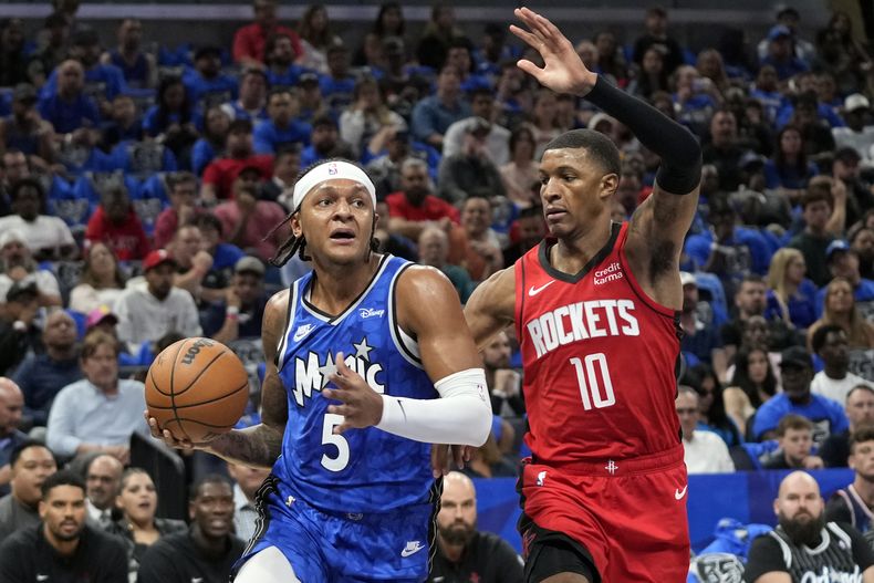 Paolo Banchero, del Magic de Orlando, avanza frente a Jabari Smith Jr., de los Rockets de Houston, en el partido del miércoles 25 de octubre de 2023 (AP Foto/John Raoux)