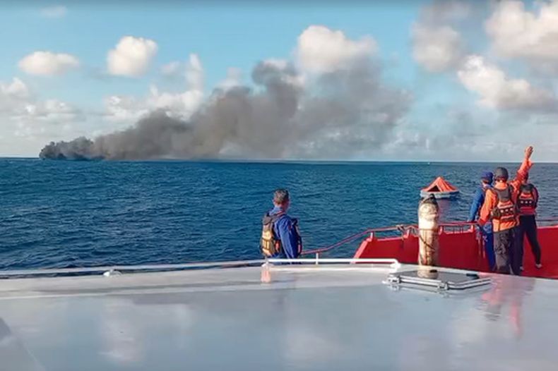 En esta imagen tomada de un video de la Agencia Nacional de Indonesia de Búsqueda y Rescate (BASARNAS), la tripulación de una embarcación de rescate observa una columna de humo después de que un ferry de pasajeros se incendió después de partir de la isla de Bali hacia la isla de Lombok, el miércoles 12 de agosto de 2026, en el estrecho de Lombok, Indonesia (BASARNAS via AP)