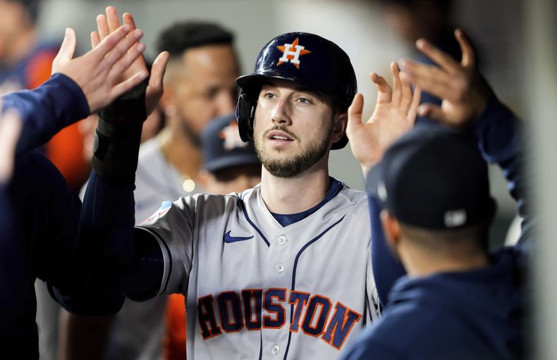 Kyle Tucker, de los Astros de Houston, es felicitado en la cueva luego de anotar ante los Marineros de Seattle, el viernes 5 de mayo de 2023 (AP Foto/Lindsey Wasson)
