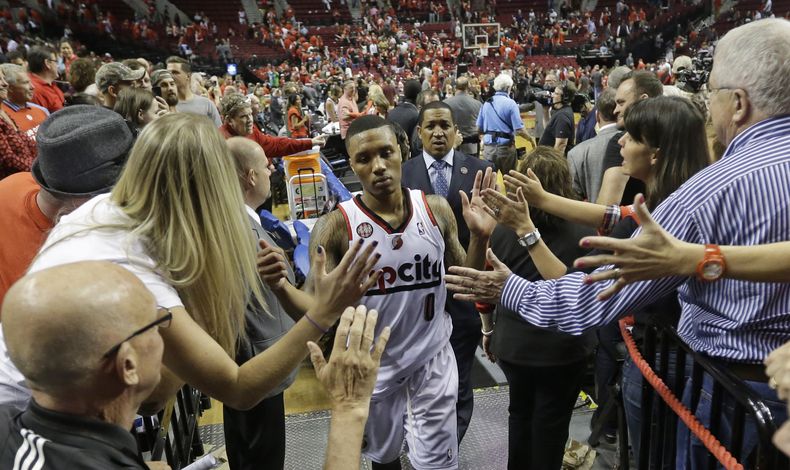Damian Lillard, de los Trail Blazers de Portland, abandona la cancha en medio de los espectadores, tras el triunfo en el cuarto encuentro de la semifinal de la Conferencia del Oeste, frente a los Spurs de San Antonio, el lunes 12 de mayo de 2014 (AP Foto/