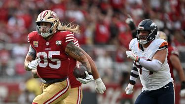 George Kittle (85), ala cerrada de los 49ers de San Francisco, corre por delante de Zach Allen, de los Broncos de Denver, y se escapa para una anotación durante la segunda mitad del partido de la NFL del domingo 4 de octubre de 2026. (AP Foto/Justine Willard)