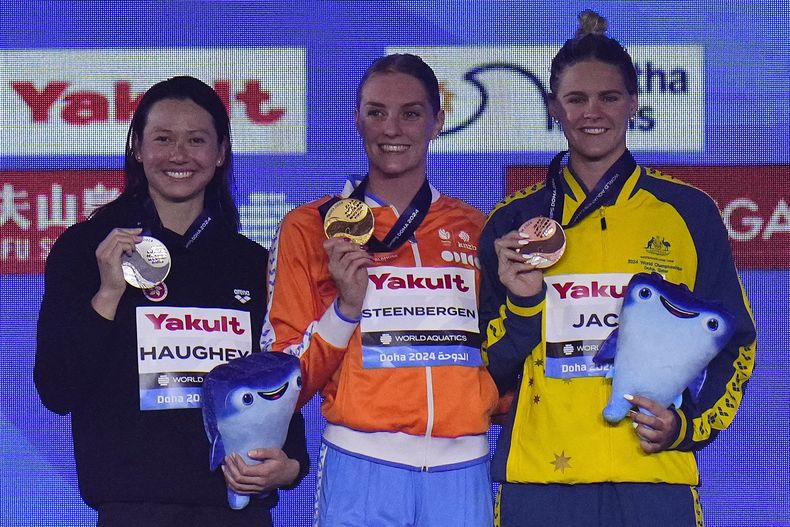 La holandesa Marrit Steenbergen posa con la medalla de oro tras ganar los 100 metros libres junto a Siobhan Haughey de Hong Kong, con la plata y Shayna Jack de Australia, con el bronce en el Campeonato del Mundo en Doha, Qatar el viernes 16 de febrero del 2024. (AP Foto/Lee Jin-man)
