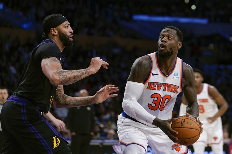 Julius Randle, alero de los Knicks de Nueva York, dribla a Anthony Davis, de los Lakers de Los Ángeles, en el encuentro del lunes 18 de diciembre de 2023 (AP Foto/Ryan Sun)
