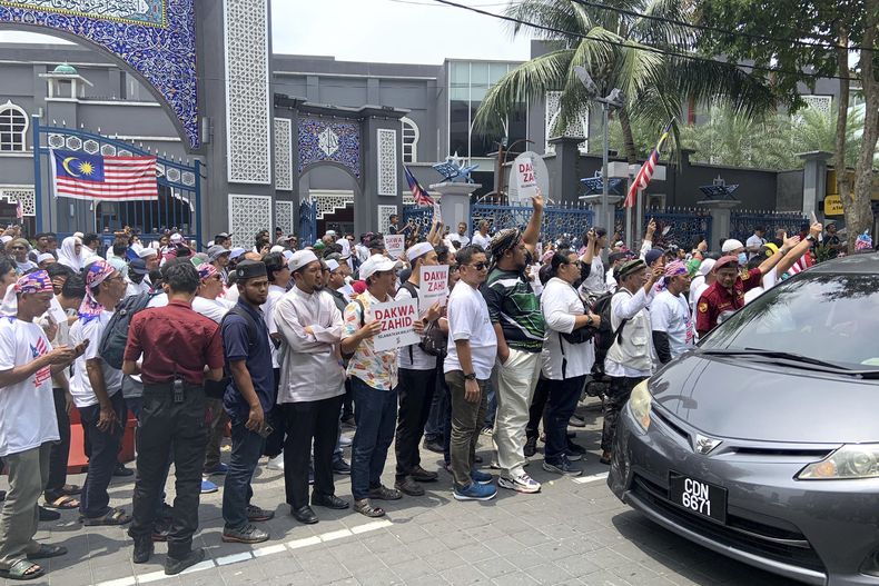 Manifestantes protestan afuera de una mezquita pidiendo que se acuse al primer ministro Anwar Ibrahim por ayudar a su principal aliado, en Kuala Lumpur, Malasia, el sábado 16 de septiembre de 2023. (AP Foto/Syawalludin Zain)