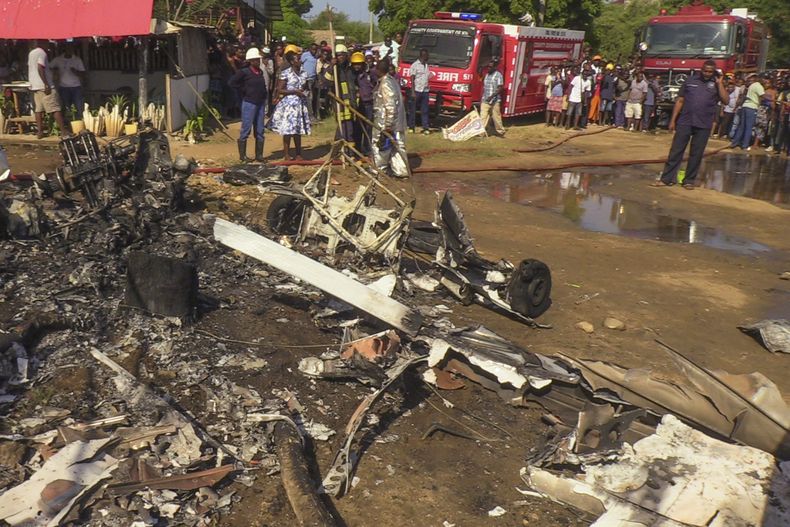 Pobladores observan os restos de una avioneta que se desplomó en la ciudad costera de Malindi, en el sur de Kenia, el viernes 10 de enero de 2025. (AP Foto/Nehemiah Okwembah)