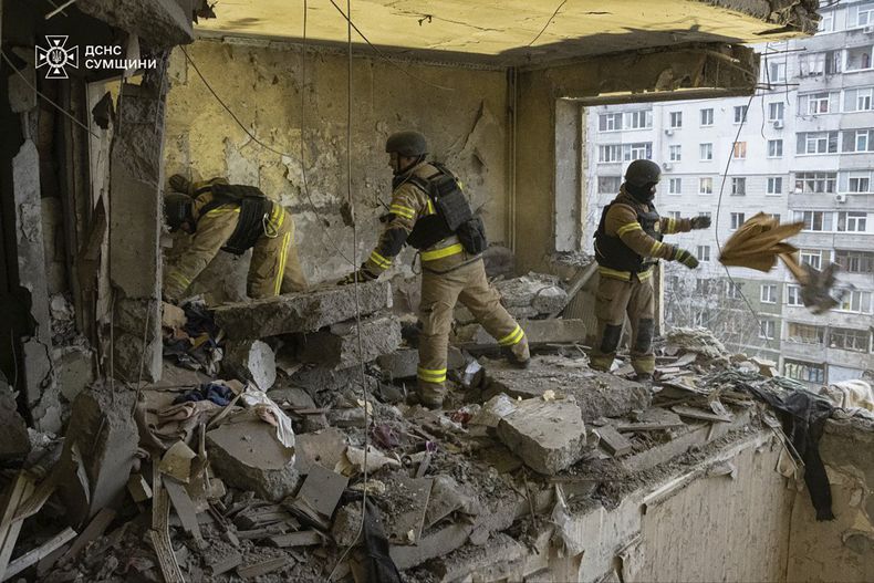 En esta foto proporcionada por el Servicio Ucraniano de Emergencias, rescatistas buscan a civiles que murieron cuando un dron ruso golpeó un edificio de apartamentos en Sumy, Ucrania el jueves 30 de 2025. (Servicio Ucraniano de Emergencias via AP)