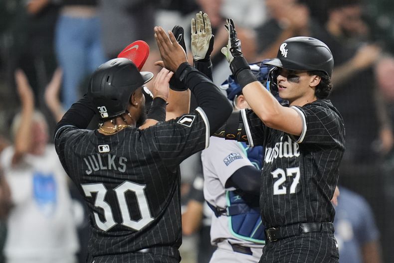 Brooks Baldwin, derecha, de Medias Blancas de Chicago, celebra con Corey Julks (30) y Dominic Fletcher, atrás, después de batear jonrón de tres carreras durante la séptima entrada del juego de béisbol en contra de los Yankees de Nueva York, el lunes 12 de agosto de 2024, en Chicago. (AP Foto/Erin Hooley)
