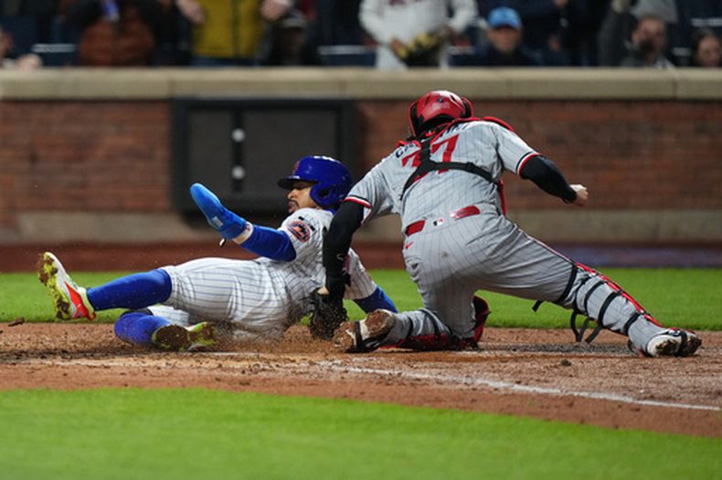 Francisco Lindor de los Mets de Nueva York se desliza para anotar una carrera ante los Mellizos de Minnesota, el miércoles 22 de abril de 2026, en Nueva York. (AP Foto/Frank Franklin II)