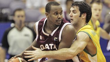 ARCHIVO - Foto del 24 de agosto del 2006, el jugador de la selección de Qatar Hashim Zaidan frente al australiano Sam Mackinnon en acciones durante el Mundial de Baloncesto en Hamamatsu, Japón. El viernes 28 de abril del 2023, FIBA elige a Qatar como sede la edición 2027 del Mundial. (AP Foto/David Longstreath, Archivo)