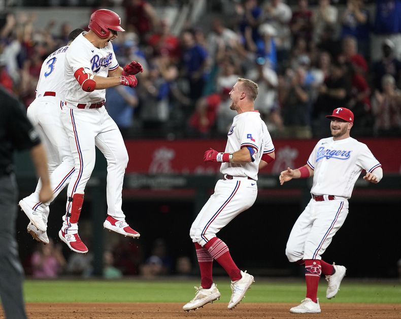 Leody Taveras, Nathaniel Lowe, Josh Jung y Robbie Grossman de los Rangers de Texas celebran el sencillo de Lowe con anotación de Marcus Semien en la victoria ante los Cardenales de San Luis el lunes 5 de junio del 2023. (AP Foto/Tony Gutierrez)