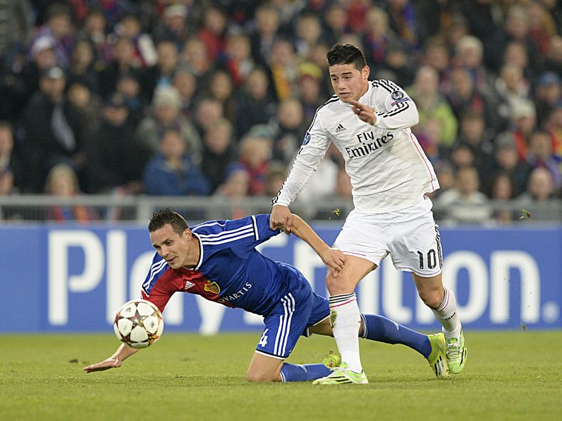 James Rodr&iacute;guez supera la marca de Philipp Degen durante un partido entre Real Madrid y Basilea por la Liga de Campeones el  26 de noviembre del 2014 en Suiza. Un tanto del colombiano ante Uruguay en la Copa Mundial figura en la terna de candidatos