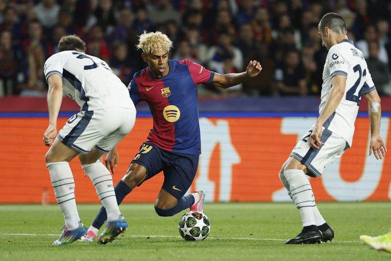 Lamine Yamal (centro) del Barcelona recorta en medio de dos defensores del Inter de Milán en la ida de las semifinales de la Liga de Campeones, el miércoles 30 de abril de 2025, en Barcelona. (AP Foto/Joan Monfort)
