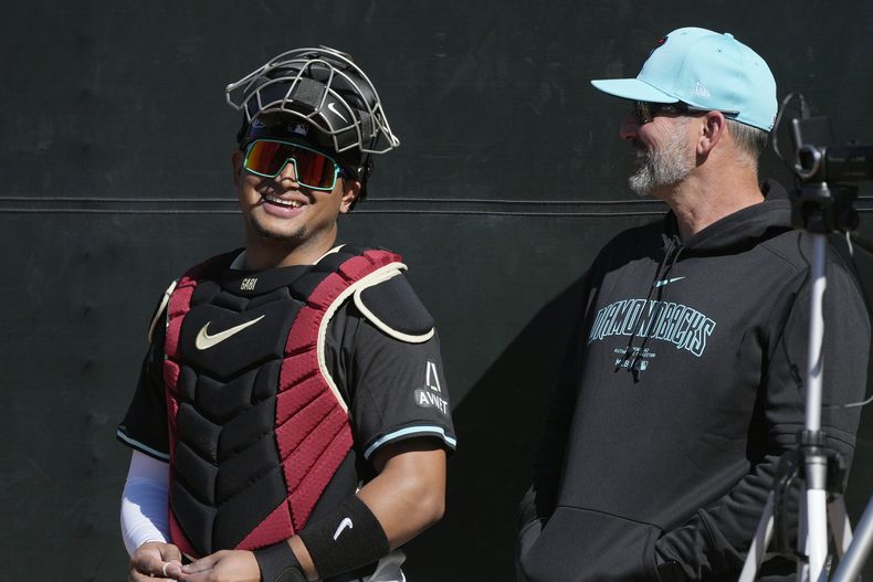 El mánager de los Diamondbacks de Arizona Torey Lovullo conversa con el receptor venezolano Gabriel Moreno, durante el entrenamiento de primavera, el miércoles 14 de febrero de 2024, en Scottsdale, Arizona. (AP Foto/Ross D. Franklin)
