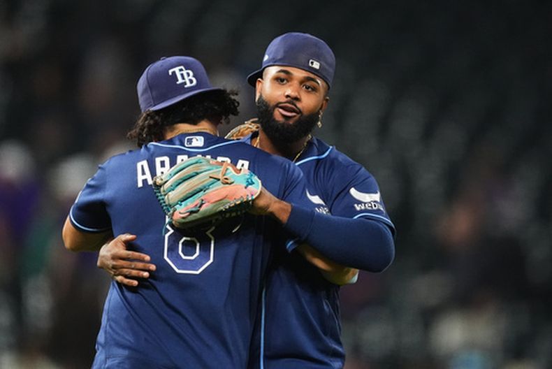 El mexicano Jonathan Aranda abraza al dominicano Junior Caminero, su compañero en los Rays de Tampa Bay, luego de imponerse sobre los Rockies de Colorado el martes 4 de agosto de 2026 (AP Foto/David Zalubowski)