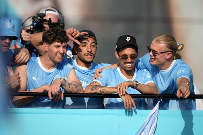 El capitán Erling Haaland (derecha) celebra con sus compañeros en un desfile de los equipos de hombres y mujeres del Manchester City, el lunes 25 de mayo de 2026. (AP Foto/Alastair Grant)