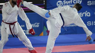 El dominicano Anel Castillo repele una patada del colombiano Diego Lenis en el combate de karate, división de más de 84 kilogramos, de los Juegos Centroamericanos y del Caribe en San Salvador, el sábado 8 de julio de 2023 (AP Foto/Arnulfo Franco)
