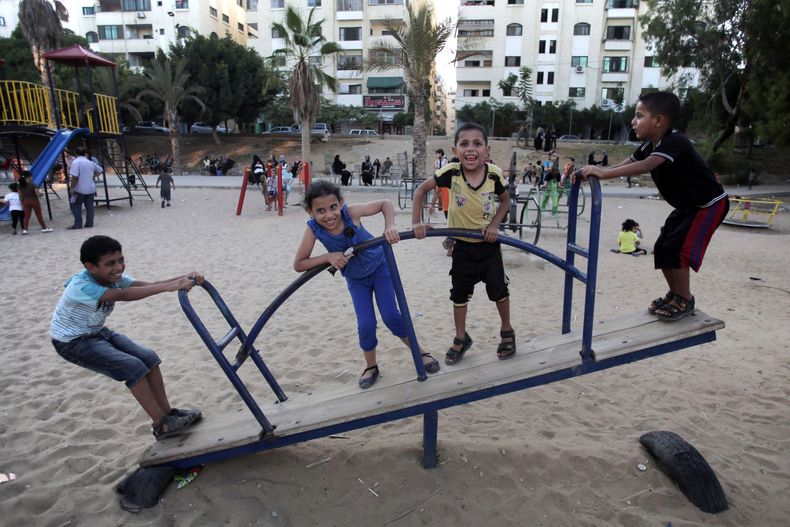 Ni&ntilde;os palestinos juegan en un parque p&uacute;blico durante un cese al fuego temporal entre el grupo extremista Hamas e Israel, en Ciudad de Gaza, el martes 5 de agosto de 2014. (Foto AP/Khalil Hamra)