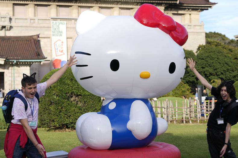 Turistas de Gran Bretaña posan con una decoración de Hello Kitty en el Museo Nacional de Tokio, donde se lleva a cabo la exposición A medida que yo cambio, ella también, para conmemorar el 50 aniversario de Hello Kitty en Tokio el miércoles 30 de octubre de 2024. (Foto AP/Shuji Kajiyama)