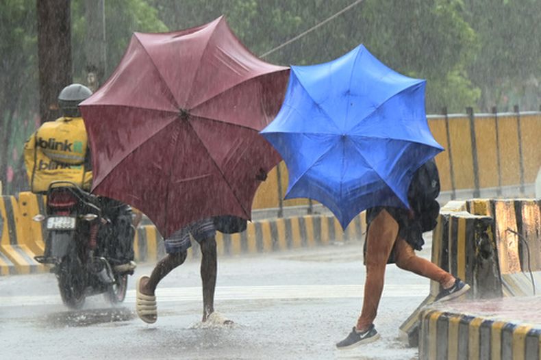 Personas usan paraguas para protegerse de los fuertes vientos a medida que el ciclón Arnab se acerca a la costa de Andhra Pradesh, en Visakhapatnam, India, el martes 27 de octubre de 2026. (AP Foto)