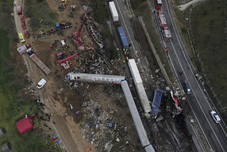 ARCHIVO - Una grúa, bomberos y rescatistas trabajan tras un choque de trenes, en la que murieron 57 personas, en Tempe, a unos 376 kilómetros (235 millas) al norte de Atenas, cerca de la ciudad de Larissa, Grecia, el miércoles 1 de marzo de 2023. (AP Foto/Giannis Papanikos, Archivo)