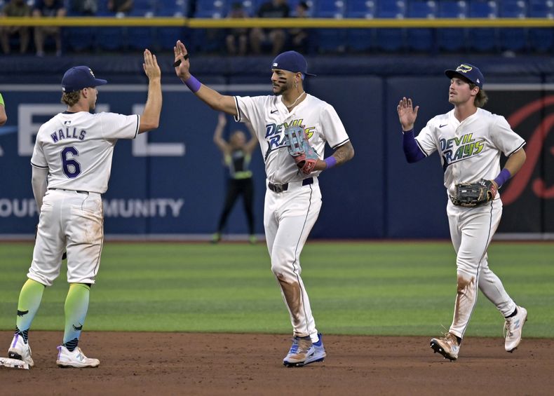 De izquierda a derecha, Taylor Walls (6), el dominicano José Siri y Jonny DeLuca festejan la victoria sobre los Nacionales de Washington, el viernes 28 de junio de 2024 AP Foto/Steve Nesius)