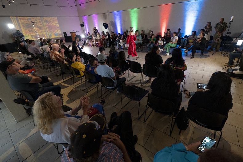 Una modelo _al centro, de rojo_, luce un vestido durante un desfile de modas con textiles guatemaltecos, el viernes 12 de mayo de 2023, en Brownsville, Texas. Elena de León, una diseñadora nacida en Guatemala, combinó técnicas indígenas de tejido, diseño moderno de ropa y colorida historia de su país natal en esa exhibición, la cual ofreció una muestra no sólo de su visión artística, sino un trabajo de madres guatemaltecas, incluidas algunas que viven en Estados Unidos y otras que se quedaron en su país para apoyar a sus familias. (AP Foto/Julio Cortez)