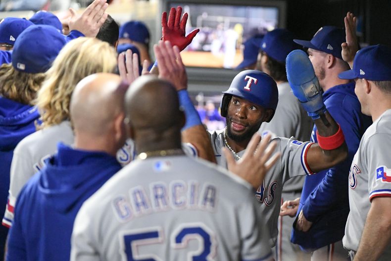 El cubano JP Martínez festeja en la cueva tras anotar una carrera por los Rangers de Texas ante los Mellizos de Minnesota, el sábado 26 de agosto de 2023 (AP Foto/Craig Lassig)