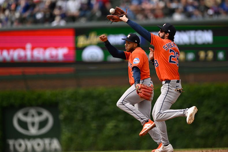 Branden Shewmake (derecha), choca con el dominicano Jeremy Peña, su compañero en los Astros de Houston, durante el juego ante los Cachorros de Chicago, el sábado 23 de mayo de 2026 (AP Foto/Paul Beaty)