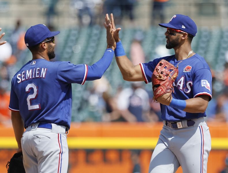 Marcus Semien (2) y Leody Taveras celebran la victoria ante los Tigres de Detroit, el lunes 29 de mayo de 2023. (AP Foto/Duane Burleson)
