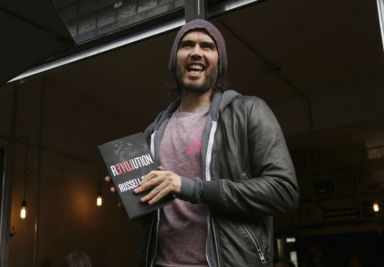 ARCHIVO - Russell Brand habla en la apertura de The Trew Era Cafe en Londres, el 26 de marzo de 2015. La policía británica instó el lunes a las mujeres que alegan haber sido agredidas sexualmente por Russell Brand a declarar ante las autoridades, mientras la industria del entretenimiento en Reino Unido enfrentaba dudas sobre si el mal comportamiento del comediante no fue cuestionado debido a su fama. (Foto Joel Ryan/Invision/AP, archivo)