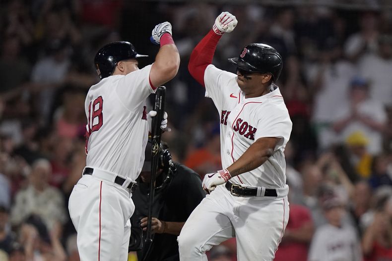 Rafael Devers, derecha, de los Medias Rojas de Boston, celebra con su compañero Adam Duvall, izquierda, después de anotar carrera con su cuadrangular en la séptima entrada del juego de béisbol en contra de los Mets de Nueva York, el domingo 23 de julio de 2023, en Boston. (AP Foto/Steven Senne)