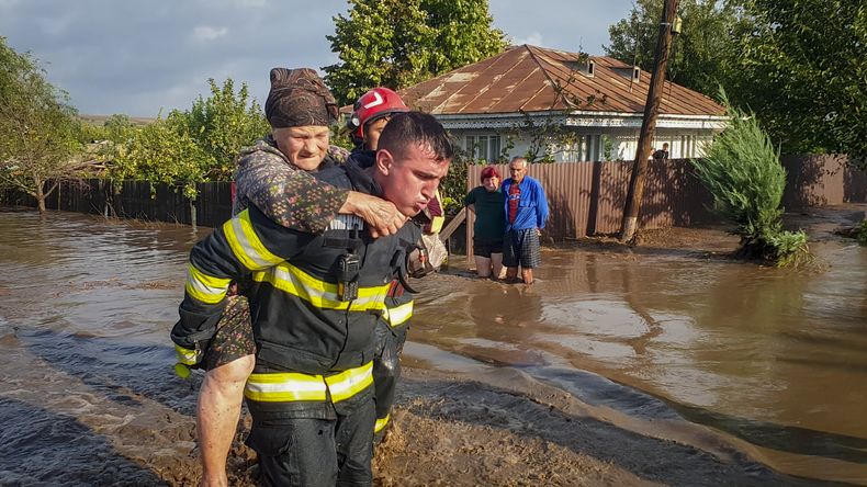 En esta imagen, distribuida por los servicios de emergencia de Rumanía, ISU Galati, un rescatista carga con una mujer a la espalda en una zona inundada en Pechea, Rumanía, el 14 de septiembre de 2024, tras las lluvias torrenciales que dejaron decenas de personas varadas. (Servicios de Emergencia de Rumanía, ISU Galati vía AP)