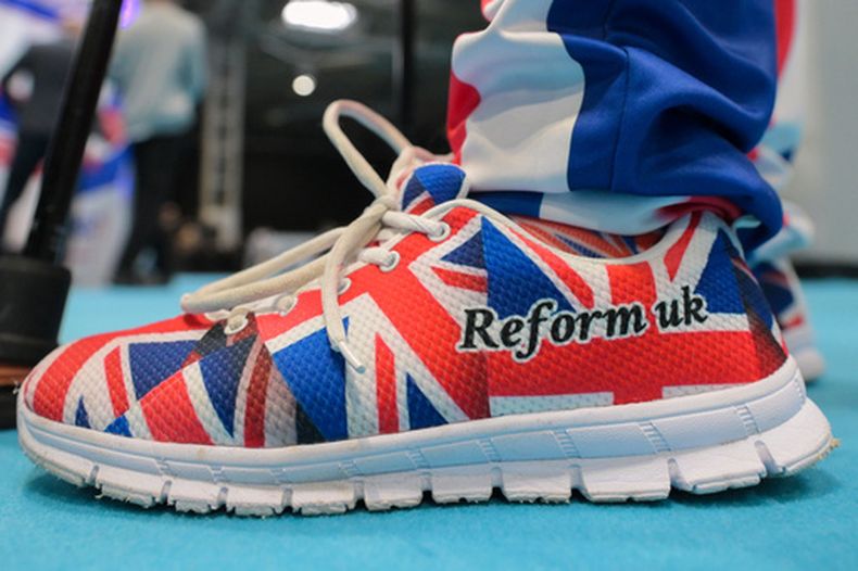 Un miembro del partido lleva zapatos con los colores de la bandera británica en la conferencia anual de Reform UK en el National Exhibition Centre en Birmingham, Inglaterra, el viernes 4 de septiembre de 2026. (AP Foto/Thomas Krych)