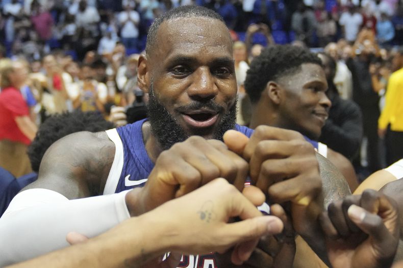 LeBron James, de Estados Unidos, celebra con sus compañeros de equipo al final de un partido de preparación de baloncesto entre Estados Unidos y Sudán del Sur, en la Arena o2 en Londres, el sábado 20 de julio de 2024. (AP Foto/Kin Cheung)