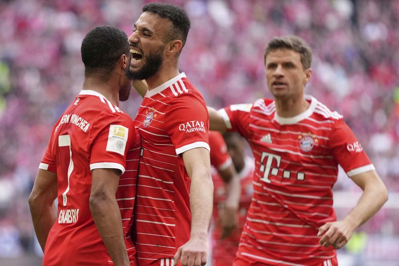 ARCHIVO - Serge Gnabry (izquierda) celebra con sus compañeros Noussair Mazraoui y Thomas Mueller tras anotar un gol para el Bayern Munich en el partido contra Hertha Berlín en la Bundesliga, el miércoles 28 de junio de 2023. (AP Foto/Matthias Schrader)