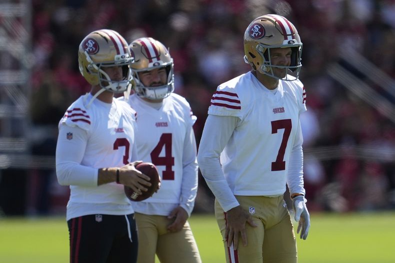 Thomas Morstead (7), pateador de despeje de los 49ers de San Francisco, se para frente a Greg Joseph, izquierda, y Jake Moody (4) durante el entrenamiento en las instalaciones del equipo el domingo 27 de julio de 2025, en Santa Clara, California. (AP Foto/Jeff Chiu)
