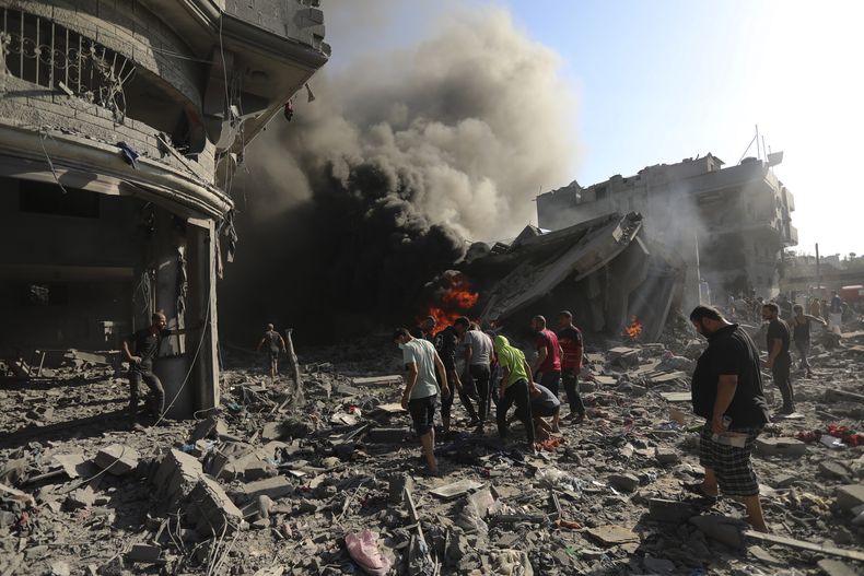 Palestinos inspeccionan los daños de una casa destruida por un ataque aéreo israelí, el sábado 4 de noviembre de 2023, en Ciudad de Gaza. (AP Foto/Abed Khaled)