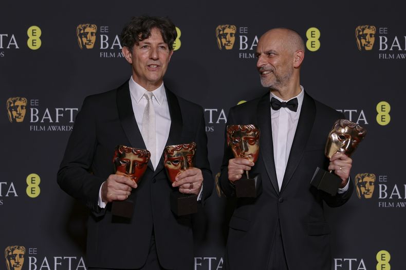 El director Jonathan Glazer, izquierda, y el productor James Wilson, ganadores del premio a mejor película británica y película en habla no inglesa por The Zone of Interest posan en la 77a entrega de los Premios de la Academia Británica de Cine (BAFTA) en Londres el domingo 18 de febrero de 2024. (Foto Vianney Le Caer/Invision/AP)
