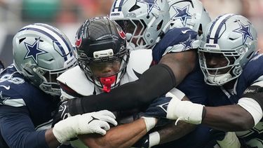 El running back David Montgomery de los Texans de Houston es derribado por los defensores de los Cowboys de Dallas, el domingo 4 de octubre de 2026, en Houston. (AP Foto/Ashley Landis)