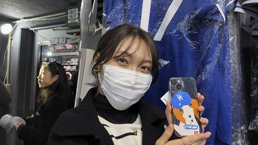 Hina Kishi muestra el diseño inspirado en Shohei Ohtani en su celular en una tienda de deportes llamada Selection en Tokio, Japón el lunes 26 de febrero del 2024. (AP Foto/Stephen Wade)