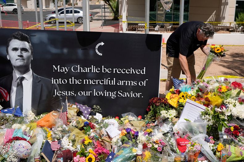 ARCHIVO - Una persona deposita flores en un memorial improvisado en honor a Charlie Kirk, en la sede de Turning Point USA, el 11 de septiembre de 2025, en Phoenix. (AP Foto/Ross D. Franklin, archivo)