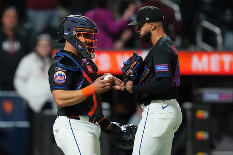 El receptor de los Mets de Nueva York, Francisco Álvarez, a la izquierda, le entrega la pelota al lanzador Devin Williams después de un juego de béisbol contra los Mellizos de Minnesota, el jueves 23 de abril de 2026, en Nueva York. (AP Foto/Frank Franklin II)
