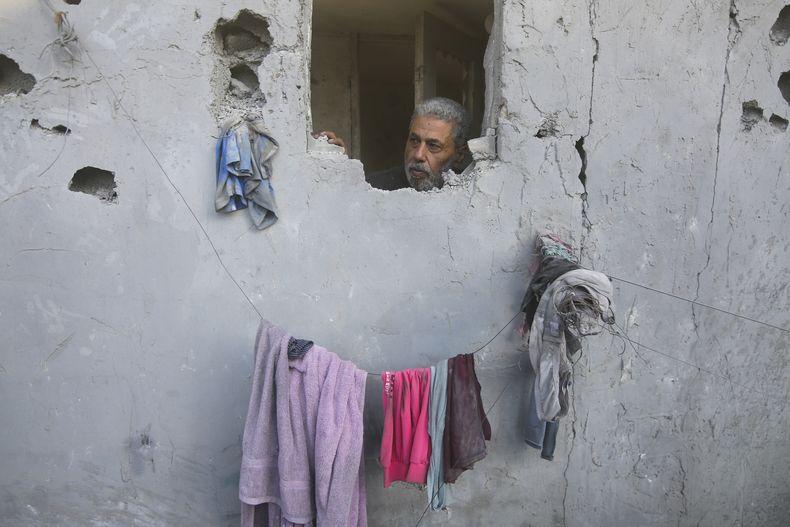 Un hombre palestino mira desde su casa dañada por ataques aéreos israelíes en Rafah, en el sur de la Franja de Gaza, el miércoles 18 de octubre de 2023. (AP Foto/Hatem Ali)
